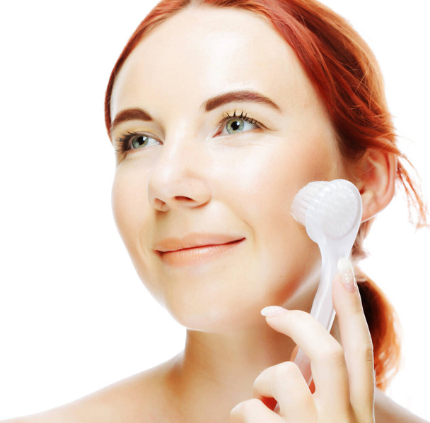 girl cleaning face with peeling brush - Foto, Imagen