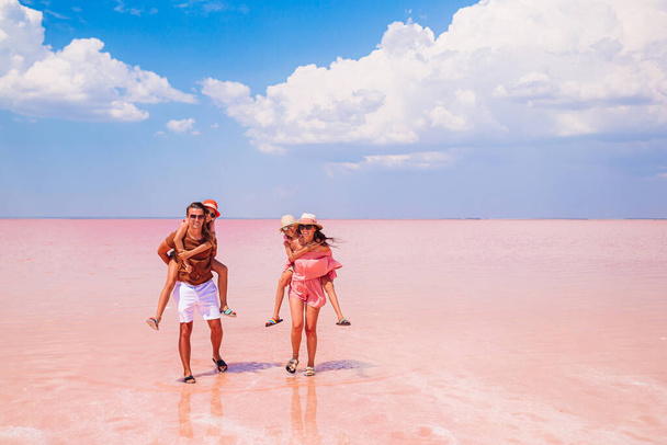 Caminhada em família em um lago de sal rosa em um dia ensolarado de verão. - Foto, Imagem