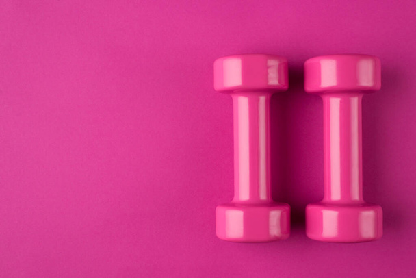 Getting fit concept. Top above overhead view photo of a pink dumbbells and a mask isolated on pink background - Valokuva, kuva
