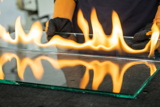 Schneiden von Sicherheitsglas, VSG (Very Safe Glass) Das Feuer brennt durch die Folie, die die Scheiben verbindet, Eine spezielle Technik zum Schneiden von Verbundglas - Foto, Bild