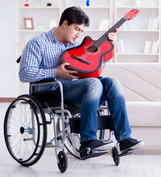 Zdravotně postižený muž hraje doma na kytaru - Fotografie, Obrázek