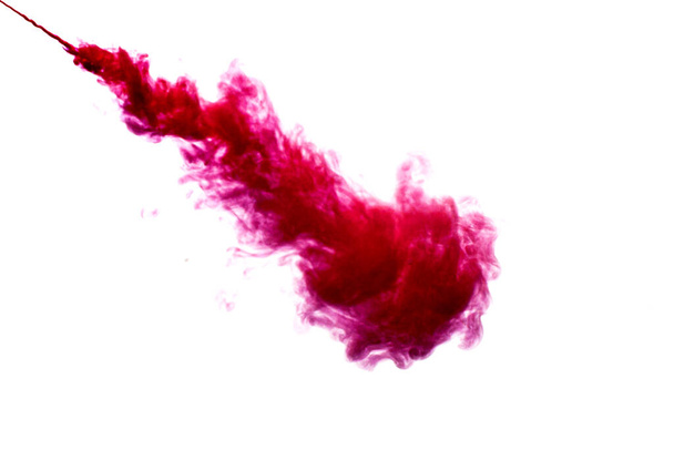 A cloud of red paint is released into the clear water. Isolate on a white background. - Foto, Bild