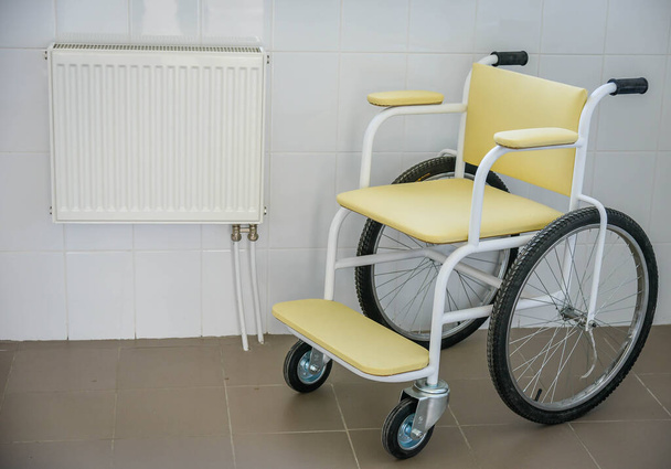Інвалідне крісло і тепла батарея в лікарні
 - Фото, зображення