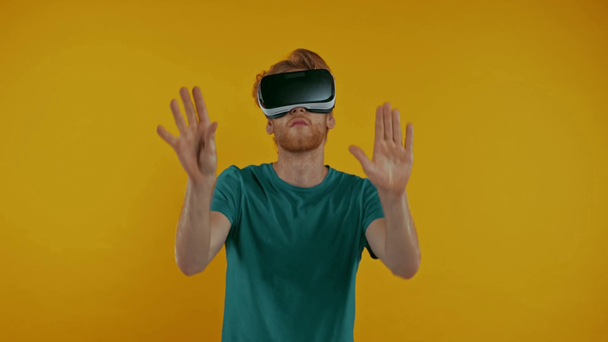 Rotschopf Mann in vr Headset gestikuliert isoliert auf gelb - Filmmaterial, Video