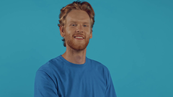 zelfverzekerde roodharige man flirten geïsoleerd op blauw - Video