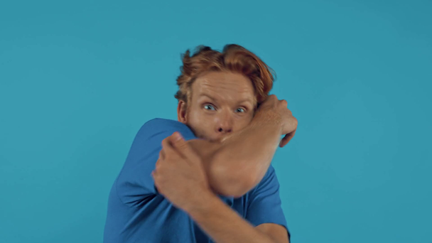 vyděšený vousatý ryšavý muž izolovaný na modré - Záběry, video