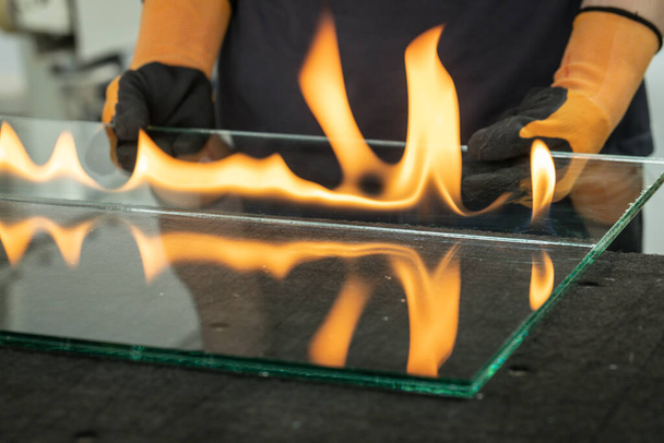 Coupe du verre de sécurité, VSG (Very Safe Glass) Le feu brûle à travers la feuille reliant les vitres, une technique spécialisée de coupe du verre feuilleté - Photo, image