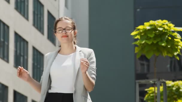 Portrait of a young successful businesswoman girl who takes off her glasses and looks confidently at the camera. The look of a confident woman smiling on a sunny day. - Filmagem, Vídeo