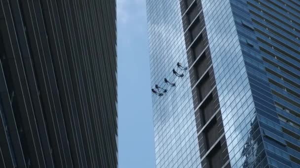 Steeplejacks trabajando en un frontispicio de un rascacielos
 - Imágenes, Vídeo