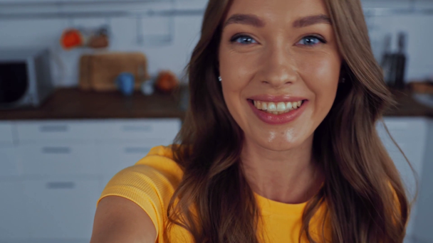 Ευτυχισμένη γυναίκα να κάνει χειρονομίες ενώ μιλάει στην κουζίνα  - Πλάνα, βίντεο