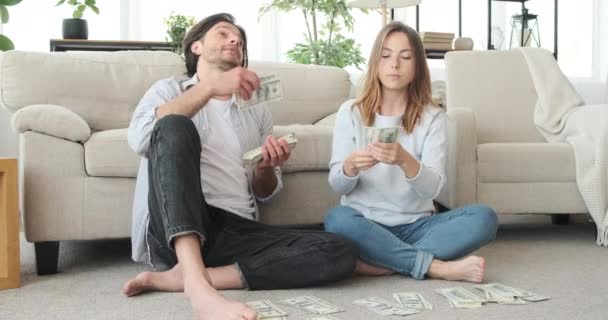Couple cools self with a fan of dollars - Materiał filmowy, wideo