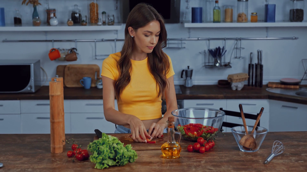 attractive girl adding bell pepper in bowl with lettuce  - Filmagem, Vídeo