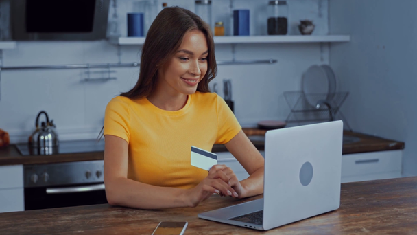 donna che utilizza il computer portatile e in possesso di carta di credito durante lo shopping online  - Filmati, video