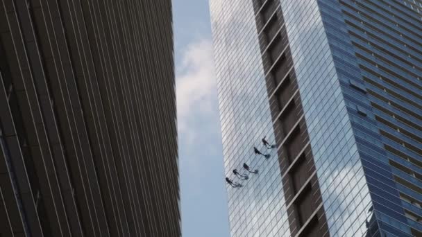 Альпинисты чистят фасад небоскреба - Кадры, видео