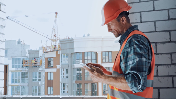 Builder taking photo with digital tablet on construction site - Footage, Video