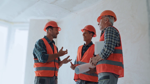 Bouwbedrijven met digitale tablet en blauwdruk in gesprek op bouwplaats - Video