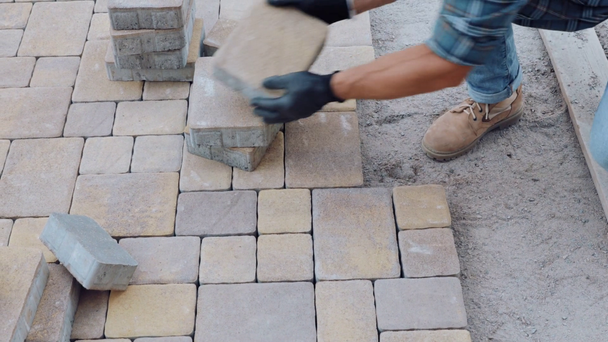 Οικοδόμος που εργάζεται με πλακόστρωτες πέτρες στο εργοτάξιο - Πλάνα, βίντεο
