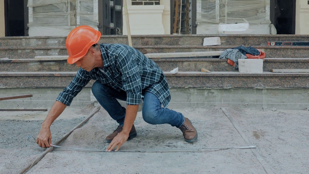 Építőipari mérőszalaggal ellátott mérőrész az építési területen - Felvétel, videó