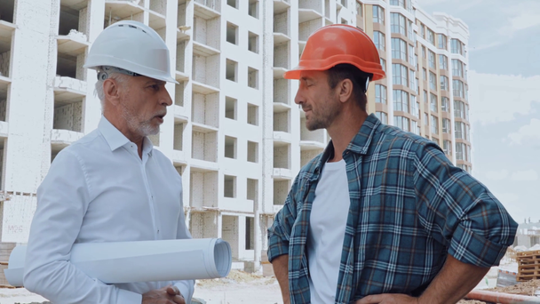Tervrajzos mérnök beszél az építésszel az építkezésen. - Felvétel, videó
