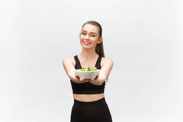 healthy fitness woman eating salad and standing, isolated on white background. - 写真・画像