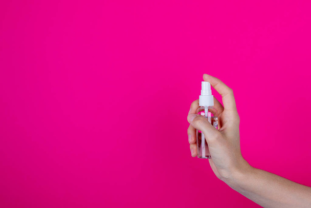 A young woman holds the antiseptic in her hand. Health care concept - Foto, Imagen
