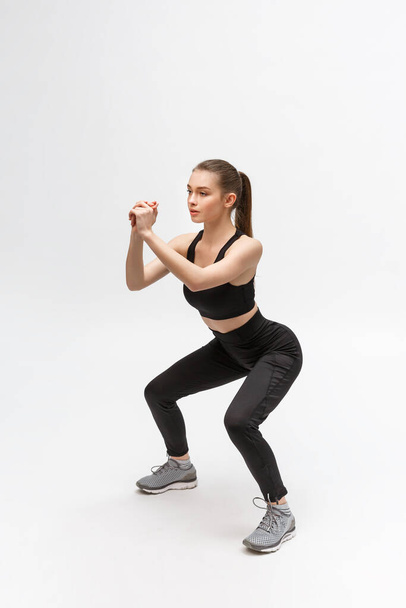Άσκηση. Αθλητική γυναίκα στο Fashion Sportswear τεντώνει τα πόδια - Φωτογραφία, εικόνα