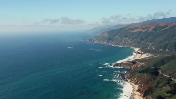 Berrak mavi gökyüzünün altındaki dağlık okyanus kıyısının ilham verici manzarası. 4K - Video, Çekim