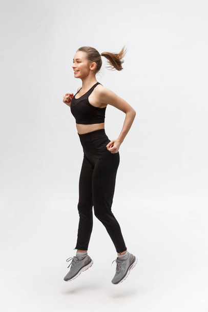 Immagine completa di felice bella donna fitness su sfondo grigio - Foto, immagini