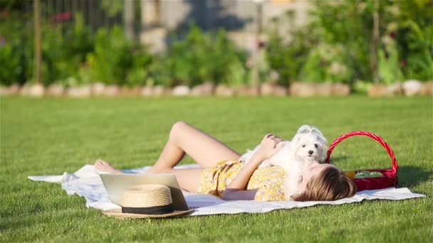 Piccola ragazza sorridente che gioca con il cucciolo nel parco - Filmati, video
