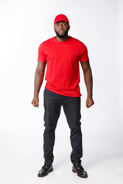 Delivery Concept - Handsome African American delivery man standing over isolated on Grey studio Background. Copy Space - Foto, Imagem