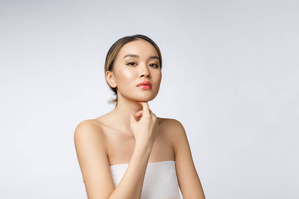 Retrato de bela mulher asiática maquiagem de cosméticos, menina mão toque bochecha, rosto de beleza perfeito com bem-estar isolado no fundo branco
 - Foto, Imagem