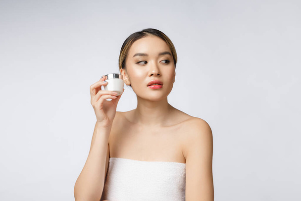 Belle femme asiatique présentant un produit isolé sur fond blanc. ESPACE DE COPIE. - Photo, image
