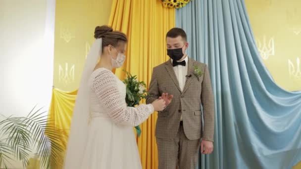 Молодята. Кавказький наречений з нареченою обмінюються кільцями на весільну церемонію. Коронавірус covid-19 - Кадри, відео