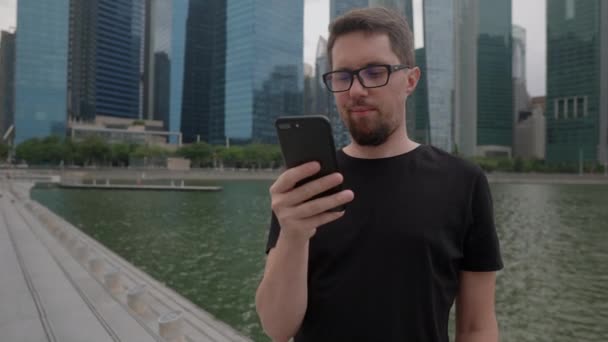 Mann mit Handy in Großstadt und sendet Nachricht - Filmmaterial, Video