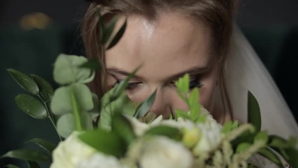 Schöne, schöne Braut im Brautschleier zu Hause. Brautstrauß in Händen von Bräutigam in Gesichtsnähe - Filmmaterial, Video