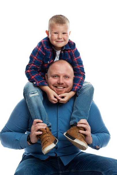 Dad and little son are smiling and hugging. Love and tenderness in a relationship. Isolated on white background. Vertical. - Foto, afbeelding