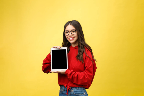 Woman using digital tablet computer PC isolated on yellow background - Foto, imagen
