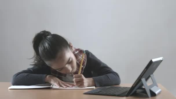 Brünettes Mädchen macht Hausaufgaben und Unterricht mit iPad-Gerät und lächelt in die Kamera - Filmmaterial, Video