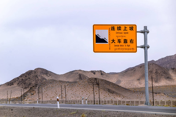 Laajalla, kuivalla erämaalla, Qinghain maakunnassa Luoteis-Kiinassa kulkee asfalttitiekuljetuksia, joissa ei ole yhtään henkilöä.. - Valokuva, kuva