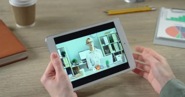 Κοντινό πλάνο του κοριτσιού που μιλάει σε βιντεοδιάσκεψη με γυναίκα συνάδελφο ενώ κάθεται στο γραφείο στο υπουργικό συμβούλιο. Οθόνη tablet με online επαγγελματική συνάντηση μεταξύ των γυναικών εργαζομένων σε tablet σε εσωτερικούς χώρους. Έννοια εργασίας - Πλάνα, βίντεο