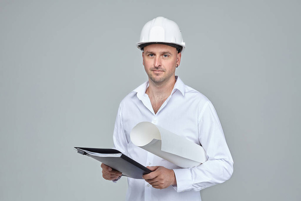 adult male in a White construction helmet. keeps the project in hand. the concept of the construction - Фото, зображення