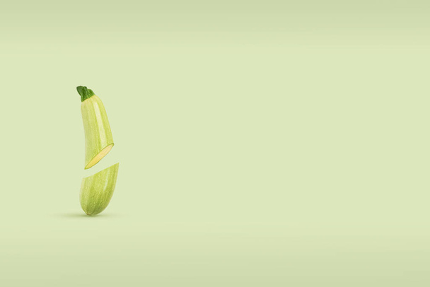 Two half fresh organic vegetable marrow soaring in air on a green background. Farm fresh produce diet concept, flying food. Vegetable banner with copy space for your text. - Foto, imagen