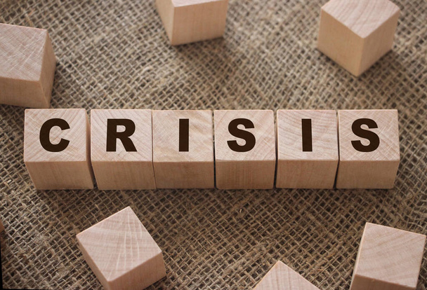 Word Crisis op houten kubusblokken op jute achtergrond. Begrip bedrijfsval. - Foto, afbeelding