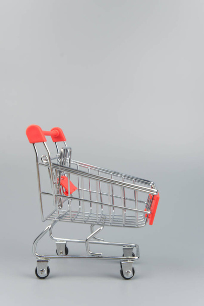 Close-up of empty shopping trolley cart on trendy gray background with copy space  - Foto, Bild