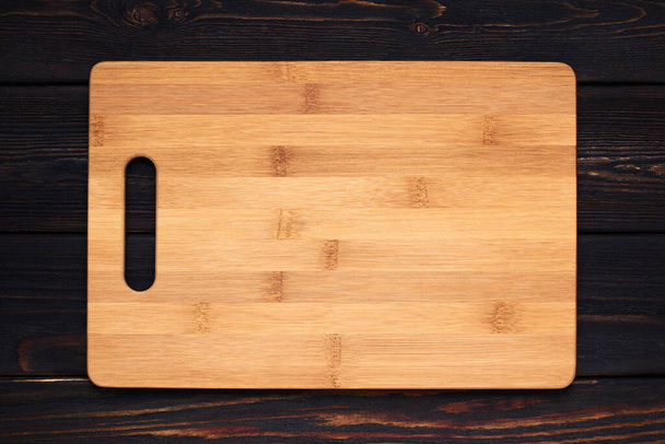 Multifunctional wooden cutting board for bread or steak serve. Top view on wooden kitchen table. Copy space - Fotó, kép