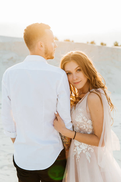サハラ砂漠、砂、砂丘で花束とピンクの結婚式の豪華なドレスで美しいカップルの愛の物語 - 写真・画像
