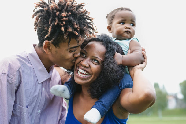 Szczęśliwa afrykańska rodzina bawiąca się razem w parku publicznym - Czarny ojciec i matka cieszący weekend z córką - Ludzie kochają i koncepcji jedności rodziców - Zdjęcie, obraz