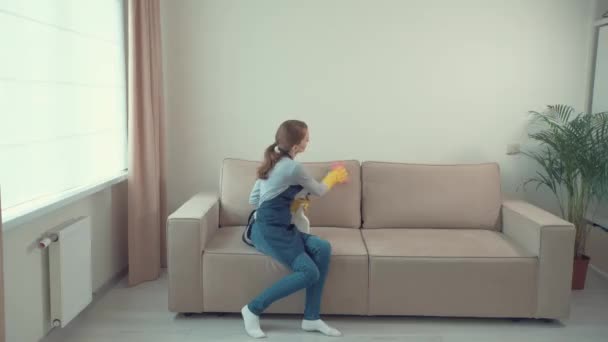A young girl washes dirty stains on a light sofa. House cleaning. - Πλάνα, βίντεο