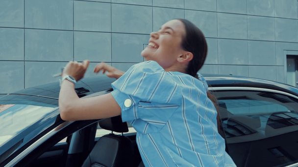 щаслива, збуджена жінка стрибає, показує ключ від машини і приймає власний автомобіль
 - Кадри, відео