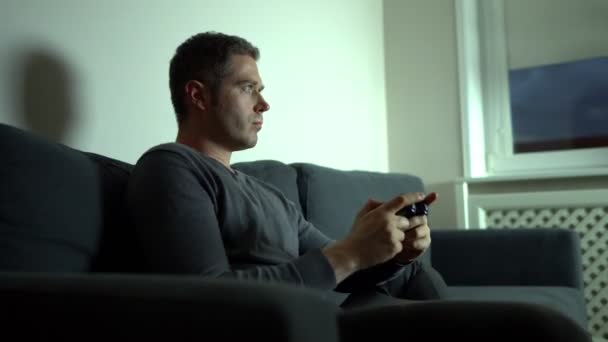 Man plays game console with joystick late at night. - Metraje, vídeo
